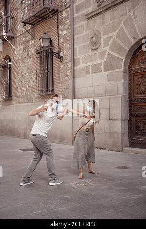 Salutation plus sûre dans la nouvelle norme. Homme et femme secouant le pied et le coude secouant en gardant la distance sociale pour éviter la propagation du coronavirus. COVID-19 Banque D'Images