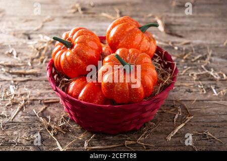 Citrouilles dans un panier rouge sur une table en bois Banque D'Images