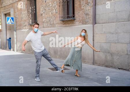 Salutation plus sûre dans la nouvelle norme. Homme et femme secouant le pied et le coude secouant en gardant la distance sociale pour éviter la propagation du coronavirus. COVID-19 Banque D'Images