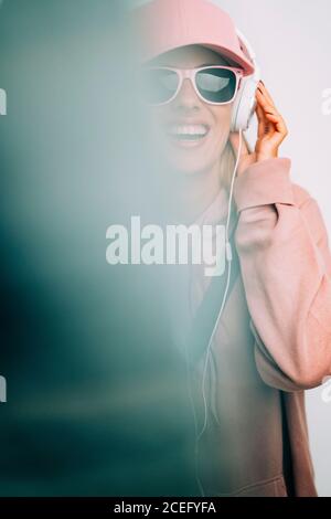 Femme en lunettes de soleil écoutant de la musique Banque D'Images