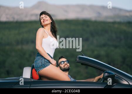 Homme et femme voyagent dans une voiture convertible. Banque D'Images