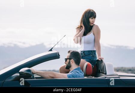 Homme et femme voyagent dans une voiture convertible. Banque D'Images