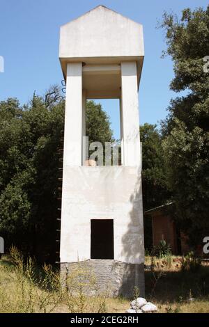 grande tour de contrôle blanche avec échelles en construction dans un défrichement boisé entre les maisons dans la lumière du jour italienne Banque D'Images