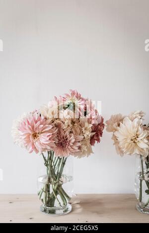 Groupe de collègues souriants, assis à table avec des gadgets et des documents tout en travaillant ensemble dans un espace de travail moderne au bureau Banque D'Images