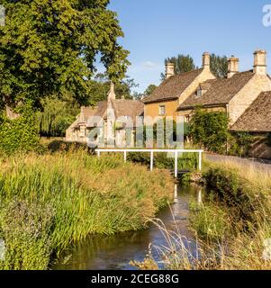 Lumière du soir sur des cottages en pierre à côté de River Eye dans le village de Cotswold de Lower Slaughter, Gloucestershire Royaume-Uni Banque D'Images