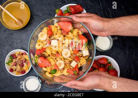 mini-bol à céréales pancake avec fraises fraîches, chocolat banane, copeaux de noix de coco et miel dans de petites assiettes. la vue du dessus. la tendance de soi Banque D'Images