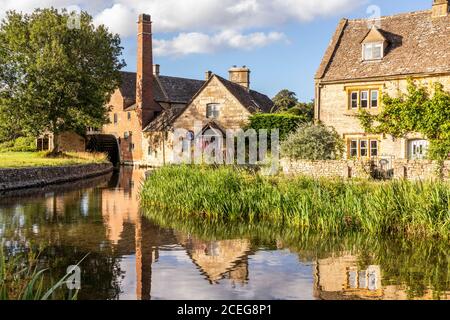 Lumière du soir sur l'ancien moulin et les cottages en pierre à côté de River Eye dans le village de Cotswold de Lower Slaughter, Gloucestershire Royaume-Uni Banque D'Images