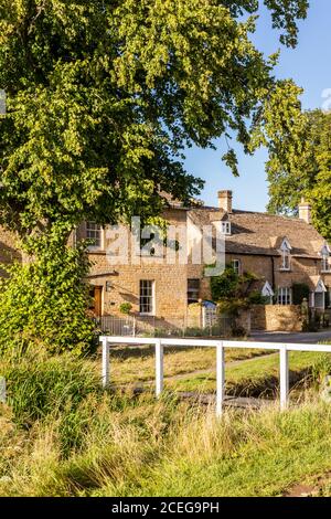 Lumière du soir sur des cottages en pierre à côté de River Eye dans le village de Cotswold de Lower Slaughter, Gloucestershire Royaume-Uni Banque D'Images