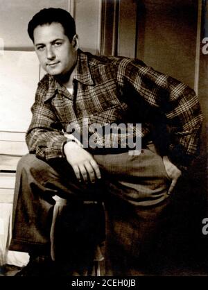 homme de 35 ans posant vers 1950 portant une chemise à carreaux et des pantalons. Banque D'Images
