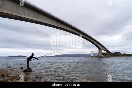 Vue sur la pêche d'homme sous le pont Skye reliant le continent à l'île de Skye, Écosse, Royaume-Uni Banque D'Images