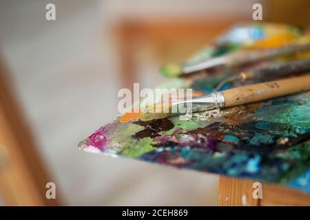 artistes pinceaux et peintures à l'huile sur une palette de bois. macro palette d'artiste, texture peinture à l'huile mélangée dans différentes couleurs et saturation. palette avec pa Banque D'Images