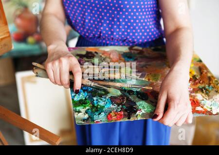 artistes pinceaux et peintures à l'huile sur une palette de bois. macro palette d'artiste, texture peinture à l'huile mélangée dans différentes couleurs et saturation. palette avec pa Banque D'Images