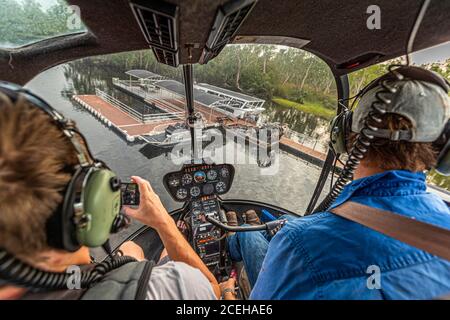 Jock au bâton de contrôle de son hélicoptère Robinson R44 Raven dans le territoire du Nord, en Australie Banque D'Images