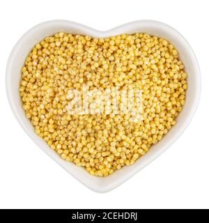 millet groats dans une assiette en forme de coeur Banque D'Images