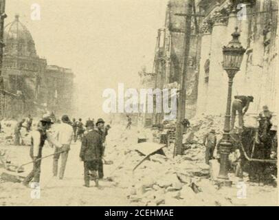 . Une histoire du tremblement de terre et des incendies à San Francisco; un compte rendu de la catastrophe du 18 avril 1906 et de ses résultats immédiats. :^SM.... Enlèvement des débris de la rue photo par Estey 1S4 THI: REPRISE croyait plus en la possession de biens qu'en l'améliorant. Les lots vacants ont été défriqués et classés, et les fondations ont été posées de bâtiments dans lesquels les chants de mer qui avaient grandi vieux dans la ville des pasteurs pour faire un nouveau départ dans la ville d'être. Les vieux bâtiments ont été élevés et les magasins construits en dessous. Parmi les grossistes, il a été décidé qu'ils devraient se rassembler sur le terrain vacant près du chemin de fer, à Banque D'Images