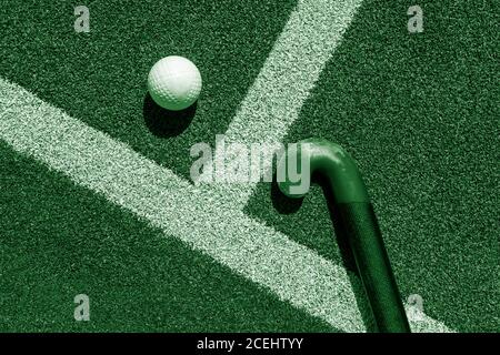 Bâton de hockey sur gazon et balle sur gazon. Filtre de couleur vert Banque D'Images