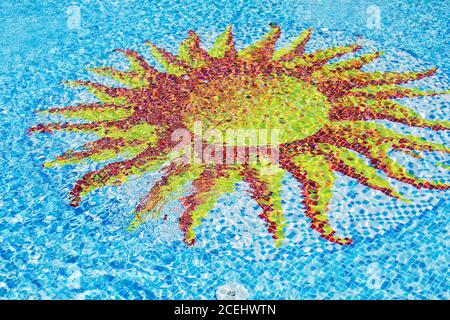 les caustiques du fond de la piscine se ondulent et s'écoulent avec la texture de fond des vagues. Fond de piscine avec élément décoratif en mosaïque sous forme de jaune Banque D'Images