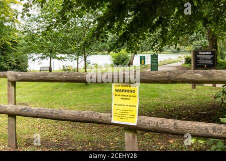 Le lac à Shearwater avis d'avertissement concernant les algues bleues qui sont présentes dans l'eau et un danger. Longleat Estate, Wiltshire, Angleterre, Royaume-Uni Banque D'Images