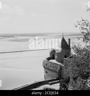 France, années 1950, vue historique du Mont-Saint-Michel, Normandie, une île marémotrice et commune montrant un coin de l'ancienne forteresse. L'île se trouve au large de la côte nord-ouest de la France, à l'embouchure du fleuve Couesnon. Le mont St Michael's à Cornwall, au Royaume-Uni, est semblable au Mont-Michel. Banque D'Images