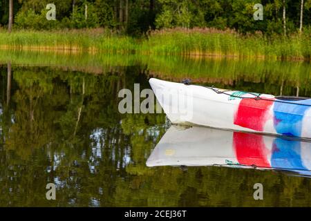 Belle vue sur le kayak coloré dissèque la surface bleue de l'eau claire de la rivière avec la forêt brumeux à l'arrière-plan, l'été ensoleillé jour. Vuoksa Banque D'Images