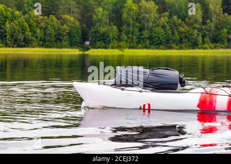 Belle vue sur le kayak coloré dissèque la surface bleue de l'eau claire de la rivière avec la forêt brumeux à l'arrière-plan, l'été ensoleillé jour. Vuoksa Banque D'Images