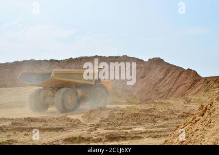 Big Yellow de camions à benne travaillant dans la mine à ciel ouvert. Transport de sable et de minéraux. Carrière minière pour la production de pierre concassée, sable et gravier pour Banque D'Images