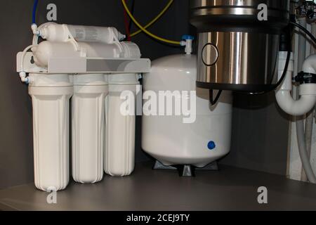 Ancien filtre domestique et tuyaux dans le système d'alimentation en eau de la maison. Filtre rouillé sale pour la purification de l'eau. Remplacement de la cartouche du filtre à eau multi-étages. Filtre