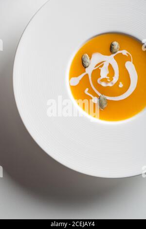 Délicieuse soupe de citrouille minimaliste sur fond blanc Banque D'Images