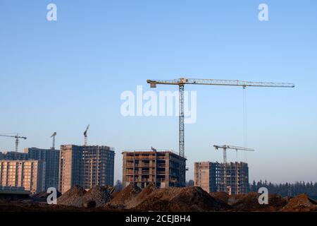 Les grues à flèche relevable hydraulique et les travailleurs en béton coulé en fondation. Verser dans du ciment clavetage des capacités au chantier de construction. T Banque D'Images