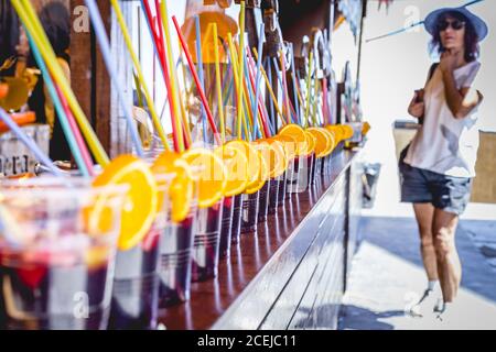 MARCHÉ MÉDIÉVAL - PUEBLA DE SANABRIA - ZAMORA - ESPAGNE - AGOUST 13, 2017: Jeune femme debout au bar avec une rangée de boissons servies avec des oranges Banque D'Images