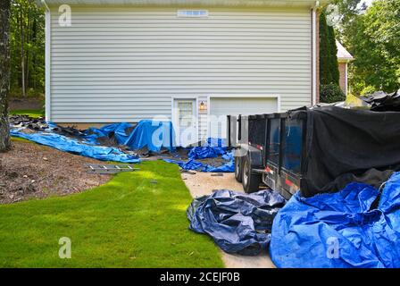 Bâches et Dumpster placés à la Maison des propriétaires comme entrepreneur Commence la dépose de l'ancien toit en préparation de l'installation d'un nouveau toit Toit Banque D'Images