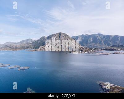Prise de vue aérienne de montagnes rocheuses sur la côte de l'océan bleu des îles Lofoten en plein soleil, Norvège Banque D'Images