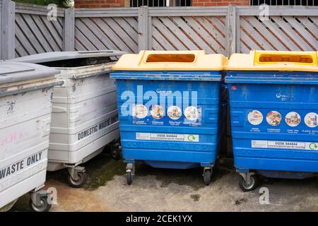 Poubelles communales et bacs de recyclage pour déchets ménagers et poubelles de recyclage pour la collecte à l'extérieur des appartements à Winterthur Way, Basingstoke, Royaume-Uni. Banque D'Images