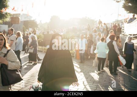 Istanbul, Turquie - août 21 2018 : femme adulte vêtue d'un arabe foncé marchant dans une rue surpeuplée en contre-jour Banque D'Images