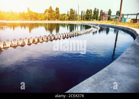 Réservoir moderne de l'usine de traitement des eaux usées urbaines à la lumière du soleil Banque D'Images