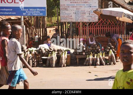 Toliara, Madagascar - 05 mai 2019: Inconnu Malgaches femmes locales qui vendent de la nourriture - principalement des tubercules - près de la route poussiéreuse. Il n'y a pas beaucoup de magasins, les marchandises sont u Banque D'Images