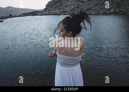 Jeune femme debout près d'un lac rippant Banque D'Images