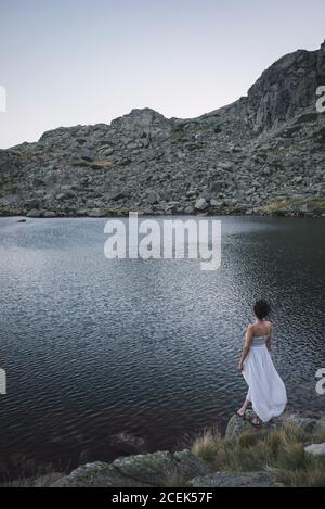 Jeune femme debout près d'un lac rippant Banque D'Images
