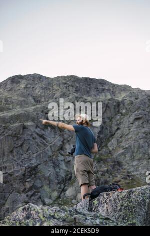Jeune homme debout sur le rocher et prenant des photos Banque D'Images
