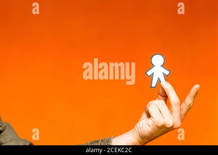 Heureux guy montrant silhouette pour papier April Fools Day orange sur fond flou Banque D'Images