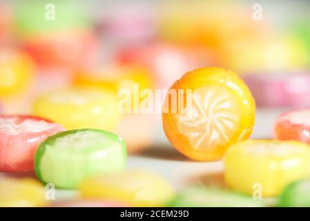 Bonbons de couleurs et de saveurs variées; un orange se distingue parmi eux. Copier l'espace. Banque D'Images