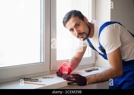 Le constructeur a mis un niveau laser sur le seuil de la fenêtre et marque Banque D'Images