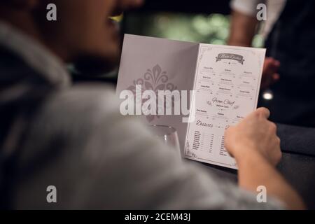 un homme lit le menu dans la barre, gros plan du menu et les mains. Banque D'Images