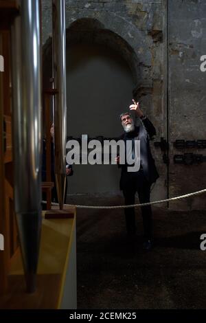 31 août 2020, Saxe-Anhalt, Halberstadt: Rainer O. Neugebauer, Président du Conseil d'administration de la Fondation d'orgue John cage Halberstadt, se dresse dans l'église Burchardi à côté de l'orgue, qui joue sans interruption la pièce musicale de John cage 'ORGAN2/ASLSP' depuis 2001. Il est éclairé par le soleil. Le morceau de musique est dit pour durer 639 ans. Le samedi 5 septembre 2020, le 14ème changement sonore du projet d'art d'orgue de John cage Halberstadt est prévu. En plus des cinq tubes précédents c'(16'), des'(16'), dis', ais' et e'', il y aura deux nouveaux tuyaux g Sharp Banque D'Images