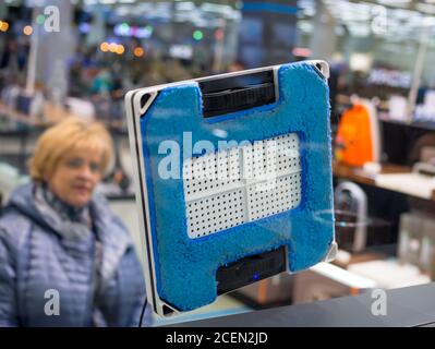 Voronezh, Russie - 22 décembre 2019: Femme regardant le robot de nettoyage de fenêtre Banque D'Images