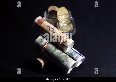 Aujourd’hui et dans l’ancienne monnaie indienne. billets et pièces de 50, 100, 200, 500 roupies. Monnaie indienne isolée sur fond noir. Banque D'Images