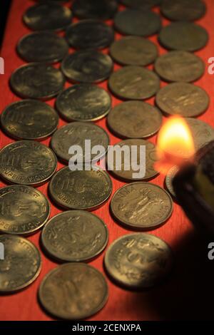 Pièces de monnaie en roupie indienne avec bougie. Pile de 1, 2, 5, 10 monnaie métallique de roupie indienne isolée sur fond rouge. Financier, économie Banque D'Images