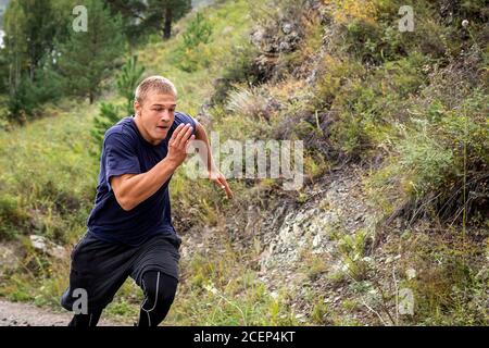 L'athlète sportif s'élève en amont dans la montagne, la rivière, les montagnes et la forêt. Course de sprint. Effet de mouvement et de course rapide, flou Banque D'Images