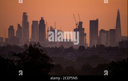 Wimbledon, Londres, Royaume-Uni. 1er septembre 2020. L'aube automnale au-dessus de Londres avec les gratte-ciels du bureau de la ville détourés contre un ciel changeant à l'approche du lever du soleil. Les maisons de banlieue et les arbres abondants au premier plan sont cueillis à travers les brumes d'automne basses. Crédit : Malcolm Park/Alay Live News. Banque D'Images