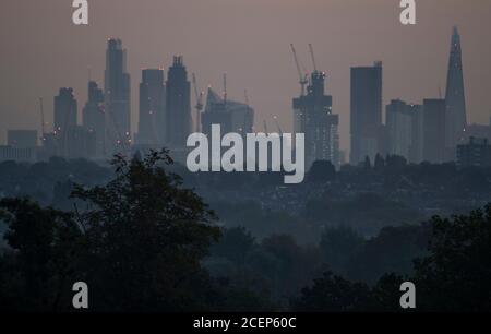 Wimbledon, Londres, Royaume-Uni. 1er septembre 2020. L'aube automnale au-dessus de Londres avec les gratte-ciels du bureau de la ville détourés contre un ciel changeant à l'approche du lever du soleil. Les maisons de banlieue et les arbres abondants au premier plan sont cueillis à travers les brumes d'automne basses. Crédit : Malcolm Park/Alay Live News. Banque D'Images